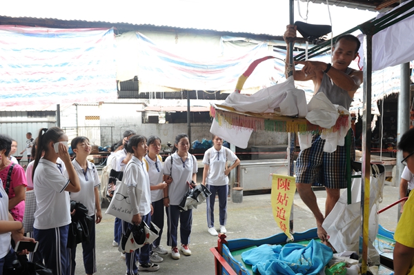 学生们认真了解飘色巡游前的准备工作